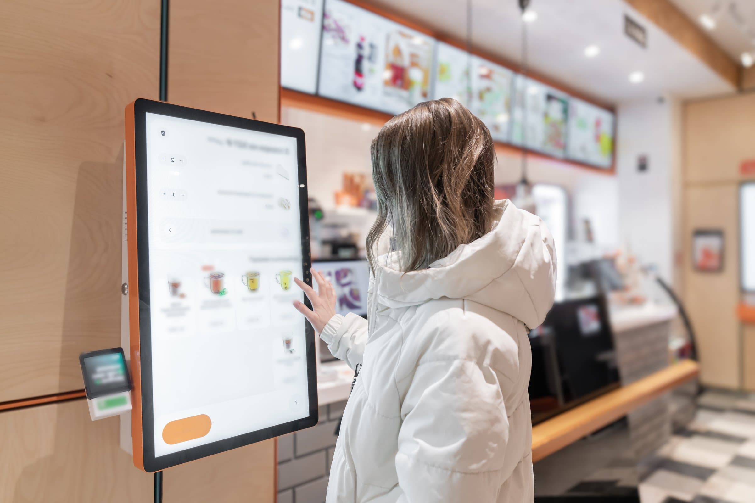 Customer using self-order kiosk at fast food counter